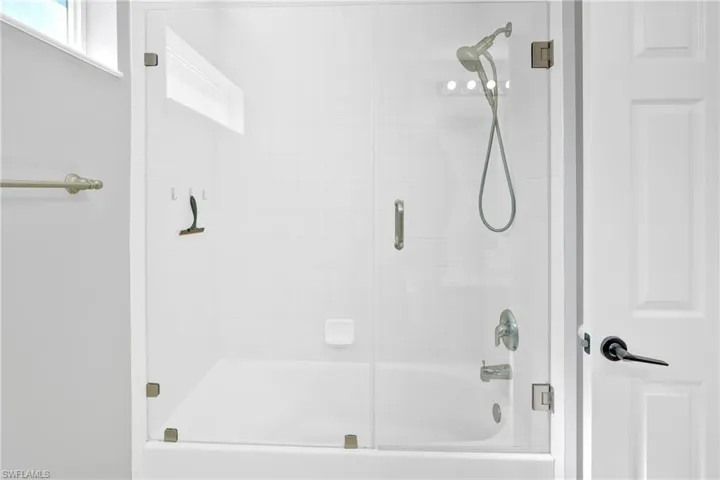 Bathroom with bath / shower combo with glass door