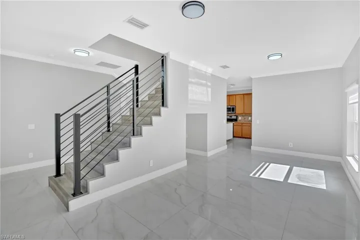 Stairs featuring crown molding and marble finish floors