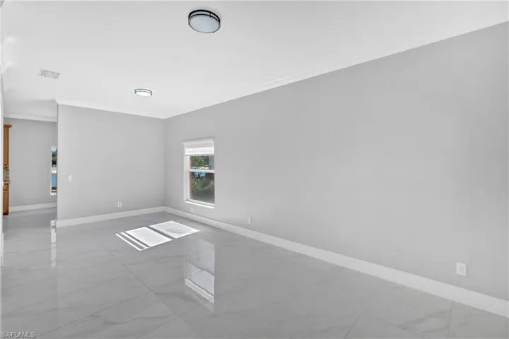 Empty room featuring crown molding and light marble finish flooring