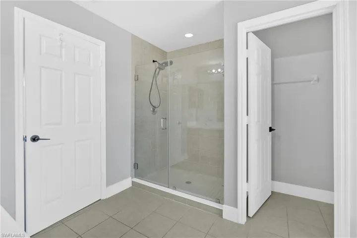 Bathroom with a stall shower, light tile patterned floors, and recessed lighting