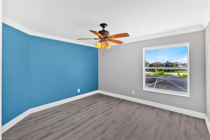 Spare room with ceiling fan, crown molding, and wood finished floors