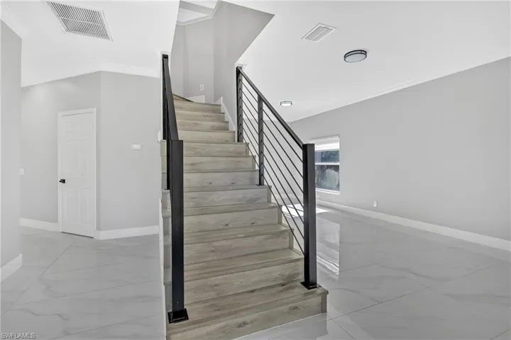 Staircase with ornamental molding and marble look tiles