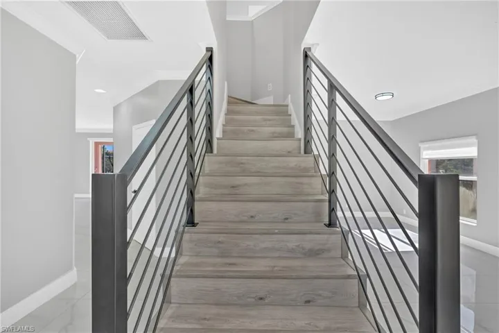 Stairway featuring crown molding, healthy amount of natural light, and recessed lighting