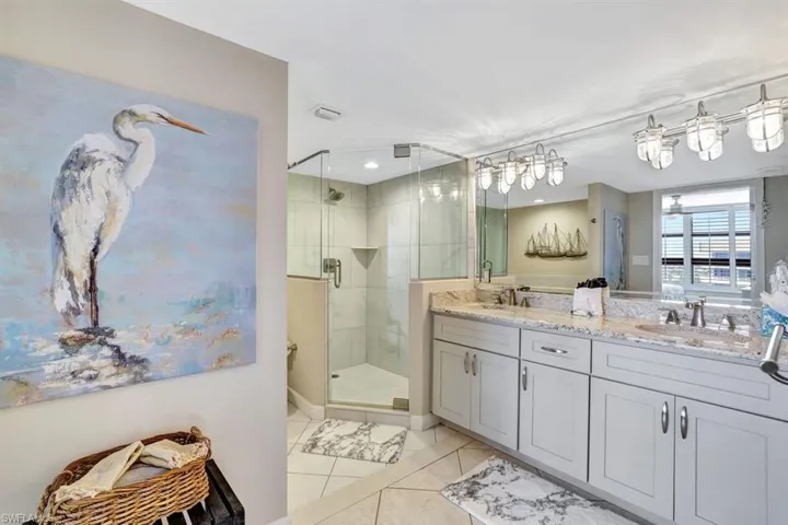 Bathroom featuring tile patterned floors, vanity, and a shower with door
