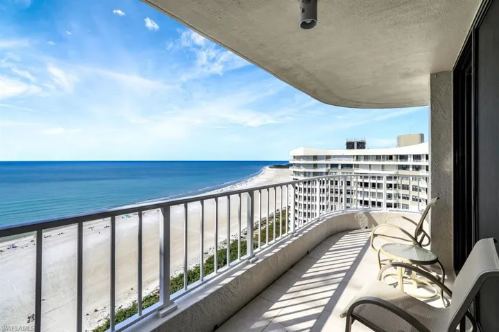 Balcony featuring a water view and a view of the beach