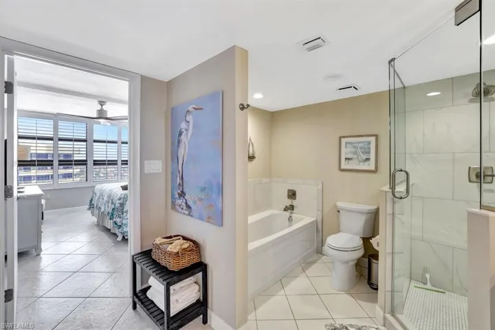 Full bathroom with tile patterned floors, vanity, plus walk in shower, and toilet