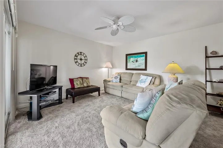 Living room with carpet and a ceiling fan