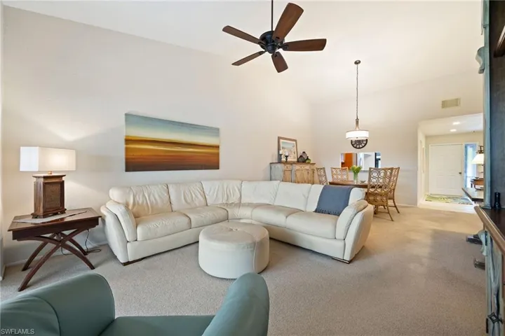 Carpeted living room featuring a ceiling fan, lofted ceiling, and recessed lighting
