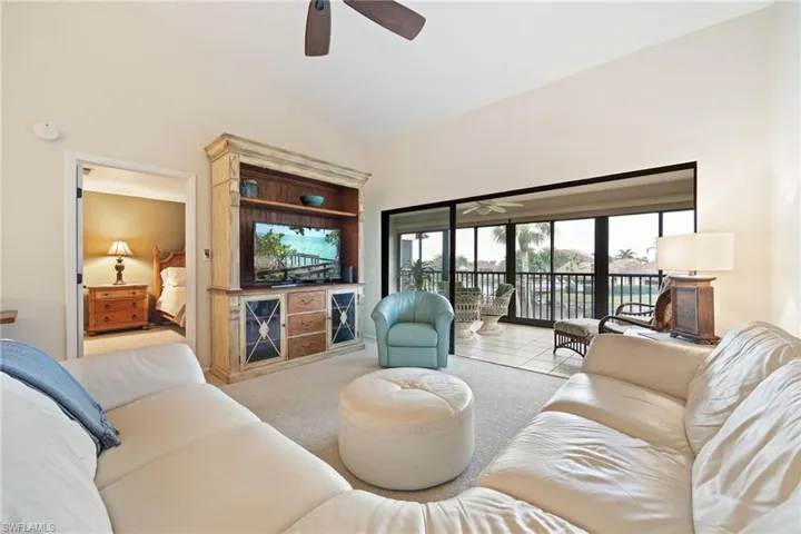 Living area with ceiling fan, lofted ceiling, and tile patterned flooring