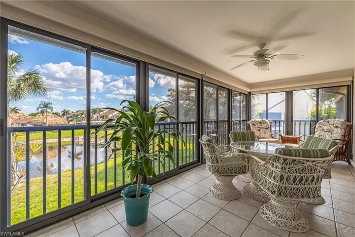 Sunroom with a water view and tile patterned floors