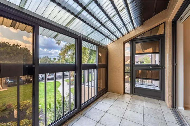 Unfurnished sunroom with a textured wall and tile patterned floors