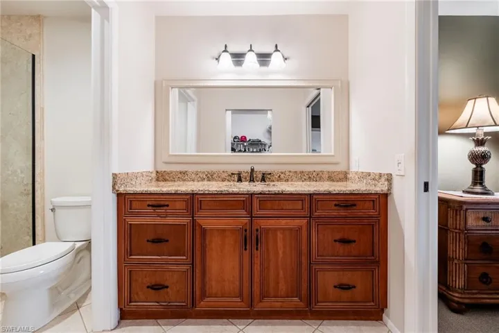 Full bath with vanity, light tile patterned flooring, and a walk in shower