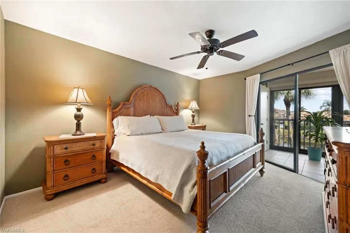 Bedroom with light colored carpet, a ceiling fan, and access to exterior