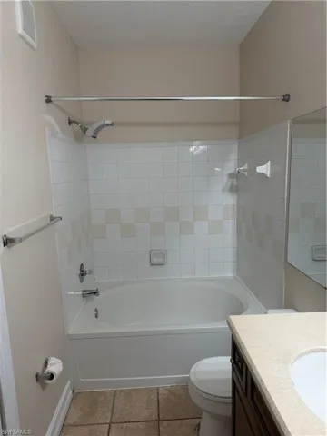 Full bath with vanity, bathing tub / shower combination, and a textured ceiling