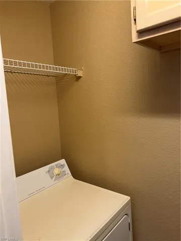 Laundry area with washer / dryer and a textured wall