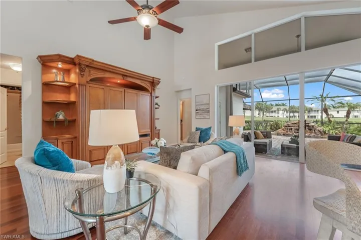 Spacious living area featuring wood-finish flooring and a built-in entertainment center with carved wood detailing