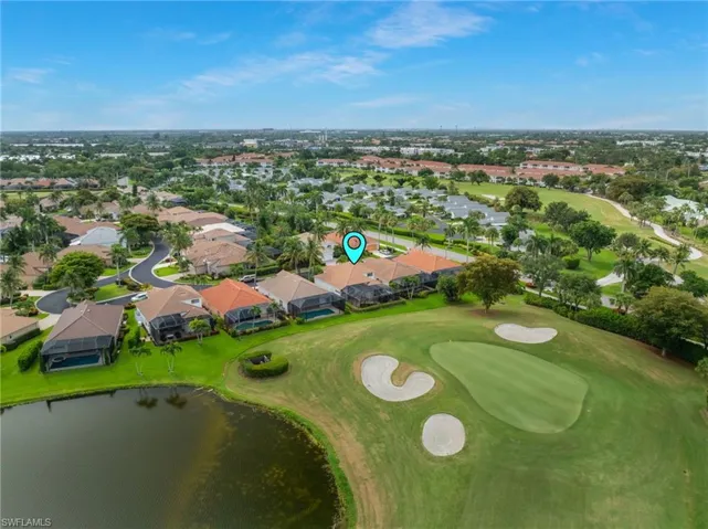 Residential property situated alongside a golf course, featuring a private pool with a screen enclosure, and a tiled roof