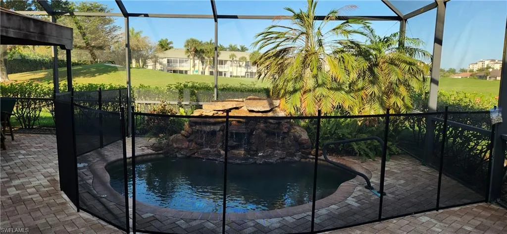 View of pool with a small pond, a sunroom, and a lanai