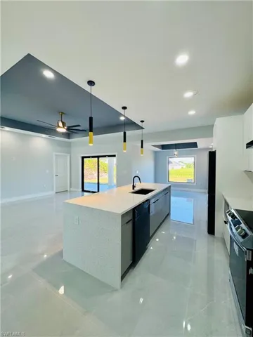 Kitchen featuring modern cabinets, stainless steel range with electric cooktop, ceiling fan, decorative light fixtures, and recessed lighting
