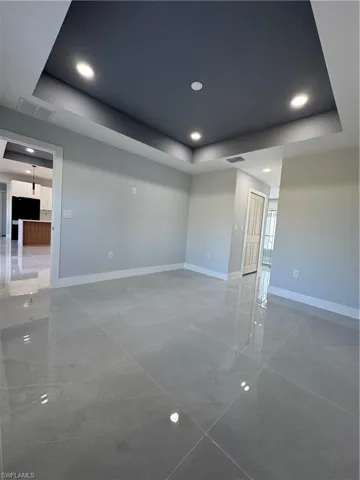 Empty room with a raised ceiling and recessed lighting
