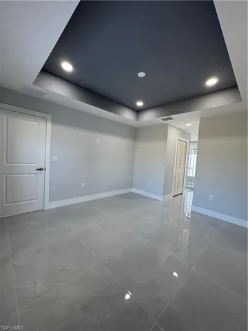 Unfurnished room featuring a tray ceiling and recessed lighting