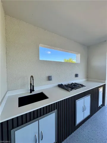 Kitchen with stainless steel gas stovetop and light countertops