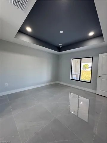Empty room with a tray ceiling and recessed lighting