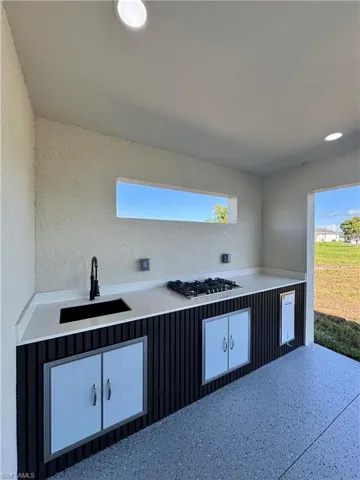 Kitchen with stainless steel gas cooktop, light countertops, and healthy amount of natural light