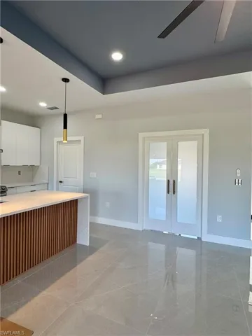 Kitchen featuring white cabinetry, french doors, light countertops, pendant lighting, and recessed lighting