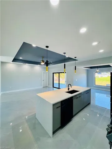 Kitchen featuring open floor plan, an island with sink, decorative light fixtures, recessed lighting, and modern cabinets