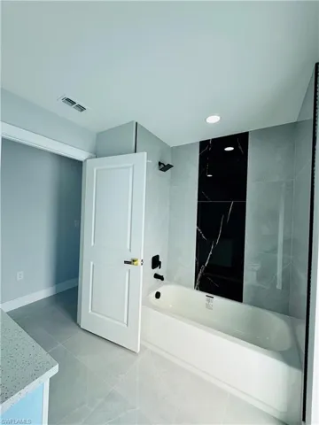 Bathroom with shower / washtub combination and vanity