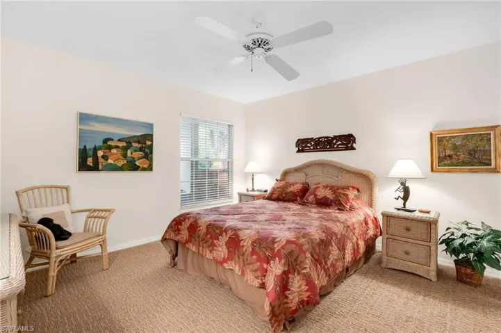 Guest bedroom with warm colors and ceiling fan.