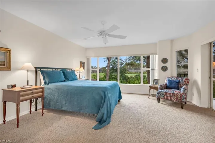 Primary bedroom with lanai access and golf course views.