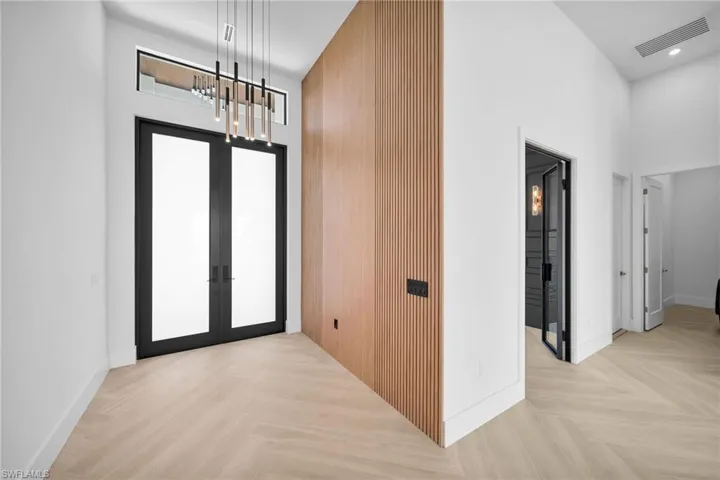 Foyer featuring a chandelier, french doors, a high ceiling