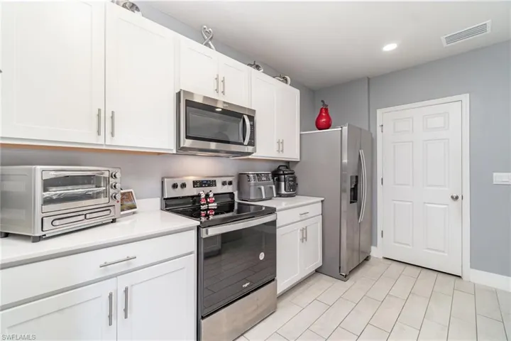 Kitchen featuring appliances with stainless steel finishes, white cabinetry, and recessed lighting
