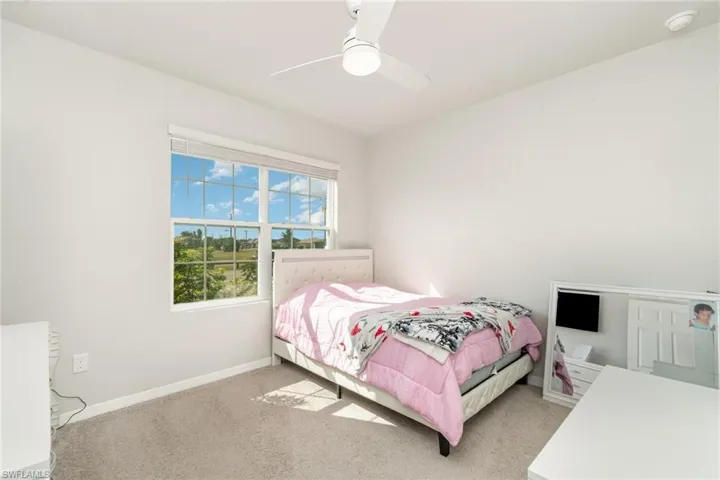 Carpeted bedroom featuring baseboards and a ceiling fan