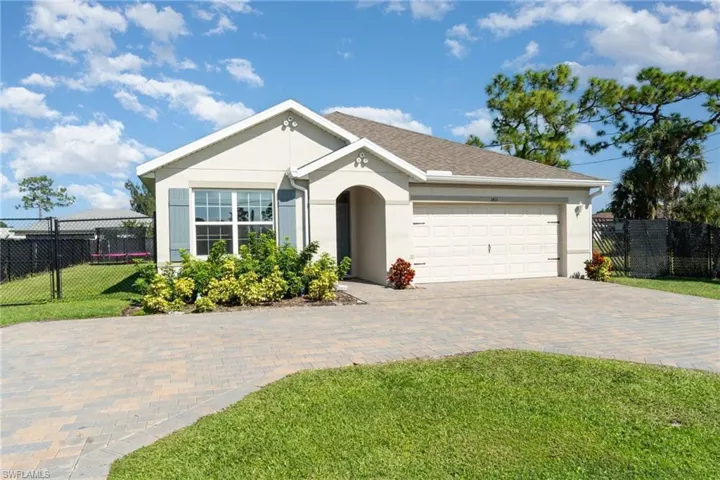 Ranch-style home featuring stucco siding, decorative driveway, and a garage