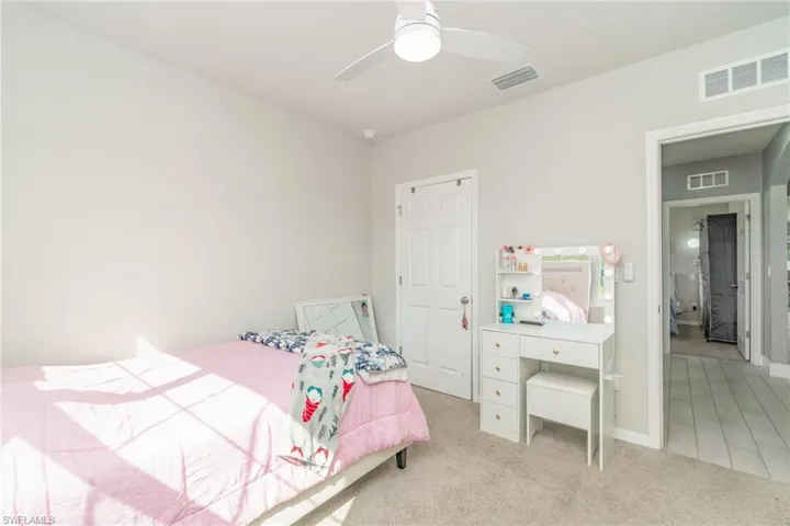 Bedroom featuring light colored carpet and a ceiling fan