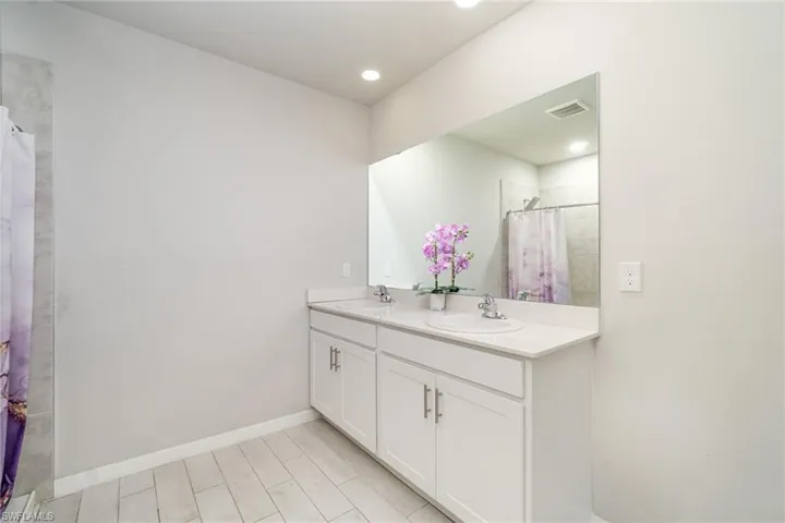 Full bath featuring double vanity and a shower with curtain