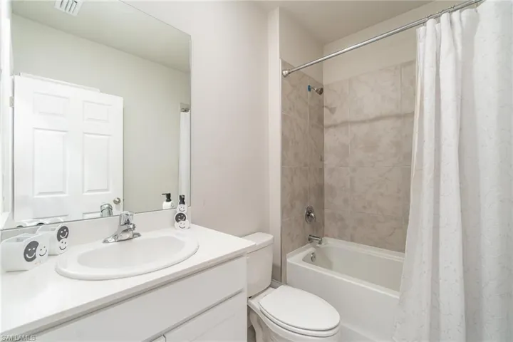 Full bath with shower / bath combination with curtain and vanity