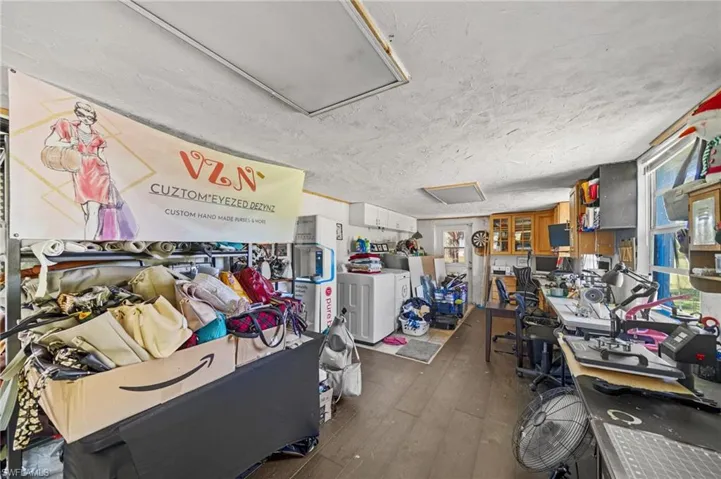 Miscellaneous room featuring dark wood-style floors, a textured ceiling, and washer and dryer