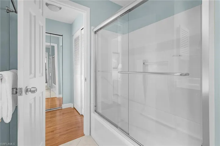 Bathroom with tile patterned flooring and shower / bath combination with glass door