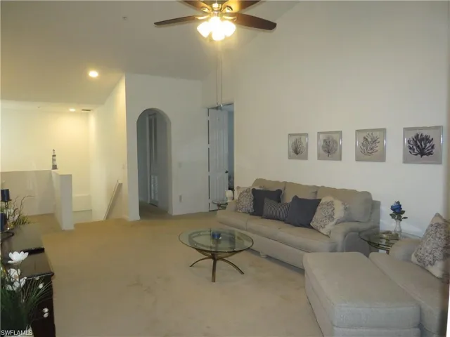 Living area featuring arched walkways, carpet floors, ceiling fan, and recessed lighting