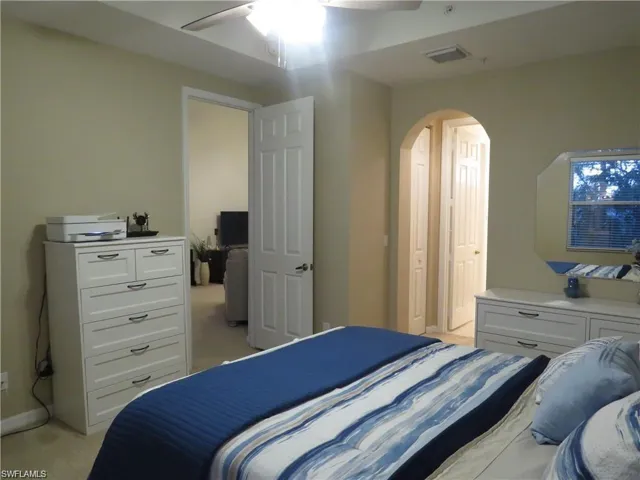 Bedroom featuring arched walkways and a ceiling fan