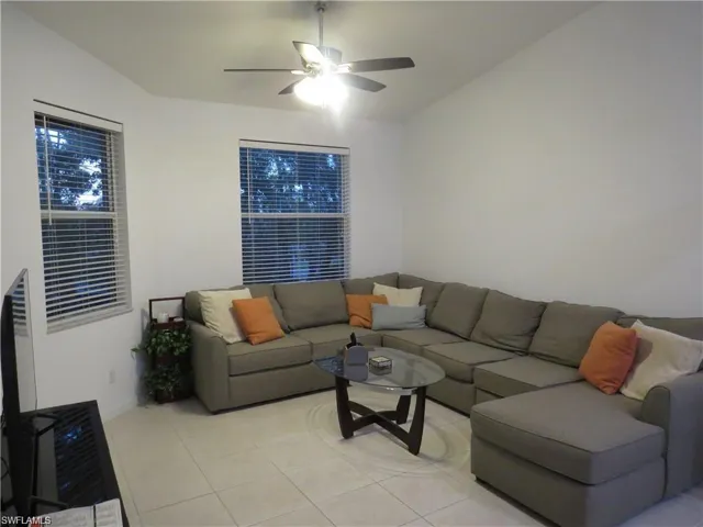 Den featuring ceiling fan and light tile patterned flooring
