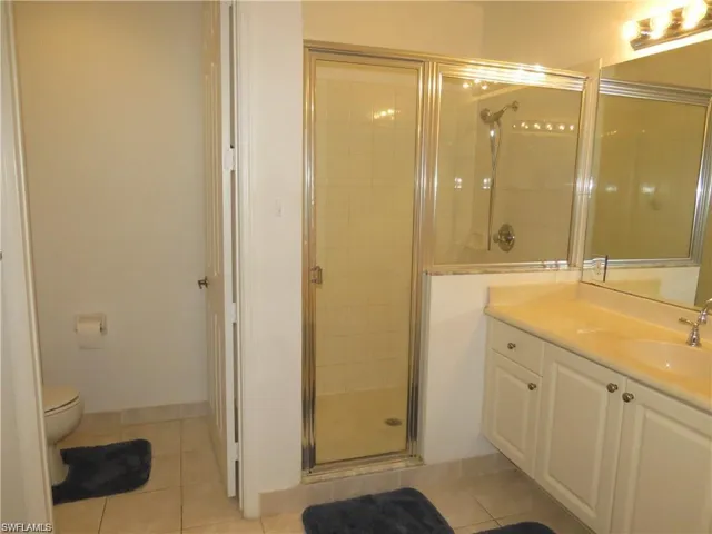 Bathroom with a stall shower, vanity, and light tile patterned floors