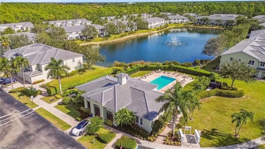 Aerial view of residential area featuring a nearby body of water and a pool