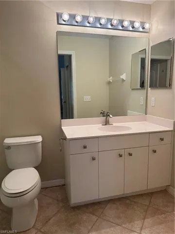 Half bath featuring vanity and light tile patterned floors