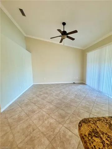 Unfurnished room featuring crown molding, ceiling fan, and light tile patterned flooring