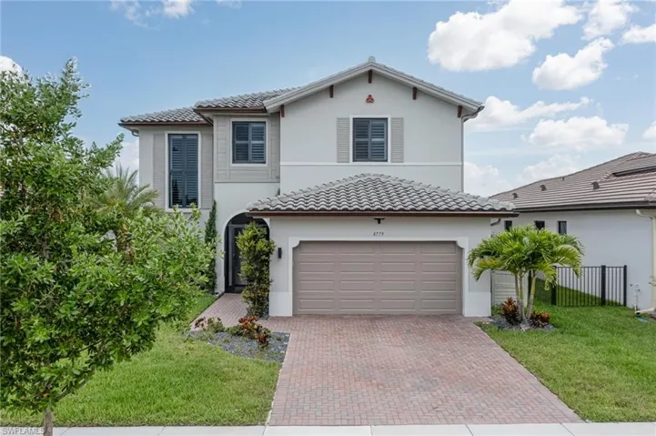 Mediterranean / spanish-style house with decorative driveway, stucco siding, and a tiled roof